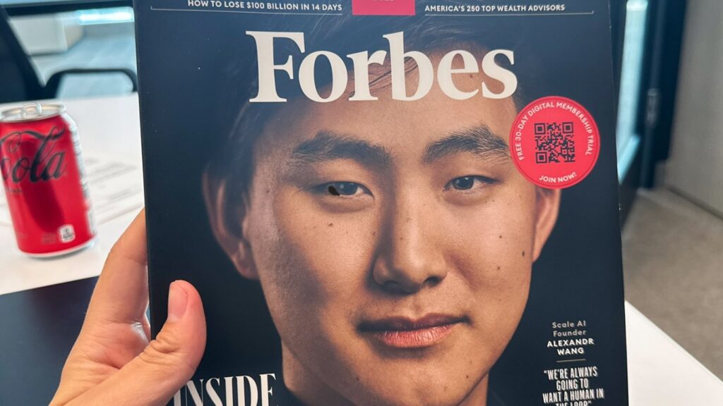 ปกนิตยสาร Forbes ฉบับหนึ่ง แสดงภาพของ Alexandr Wang ผู้ก่อตั้ง Scale AI กับข้อความที่สะท้อนบทบาทสำคัญของเขาในวงการ AI